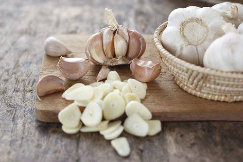 Τροφές που καθαρίζουν το συκώτι - Σκελίδες σκόρδου και σκόρδο κομμένο σε φέτες